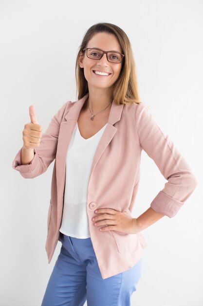 Successful young businesswoman showing thumbs up