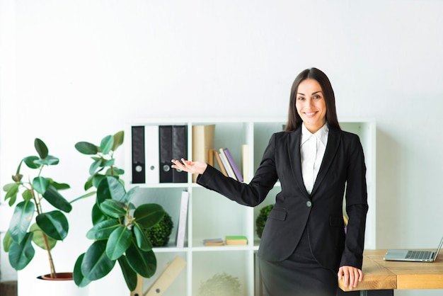 Successful young businesswoman standing in the office presenting