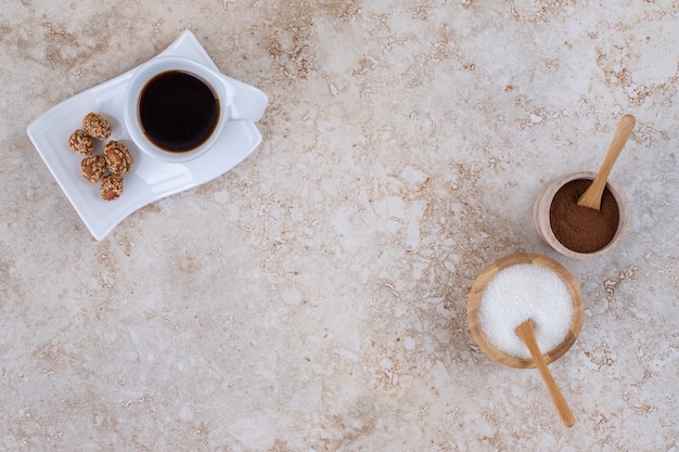 砂糖、挽いたコーヒーパウダー、一杯のコーヒー、艶をかけられたピーナッツ