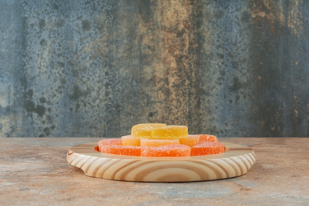 Sugar marmalade on wooden board on marble backgroun