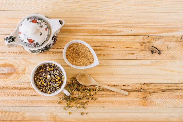 Sugar and teapot near chamomile tea