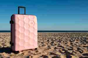 Free photo suitcase with wheels on beach