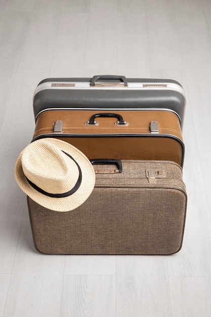 麦わら帽子をかぶった旅行用スーツケース
