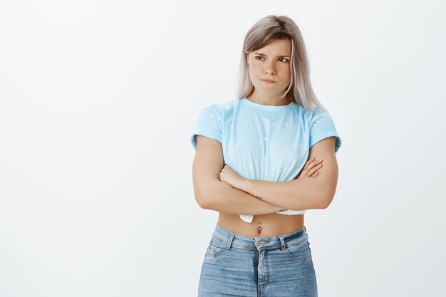 Sulking upset blonde girl posing in the studio