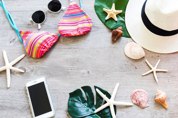 Summer accessories with seashells on wooden table