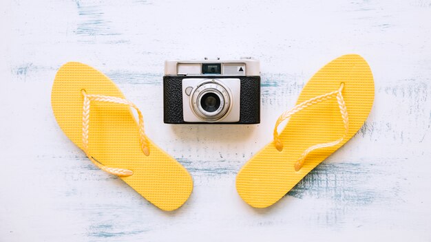 Summer background with flip flops and camera