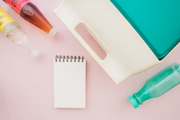 Summer composition with colored bottles and notepad