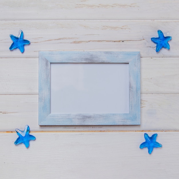 Summer composition with frame and four blue starfish