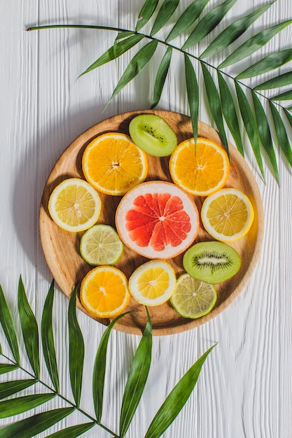 Free photo summer composition with fruits and palm leaves