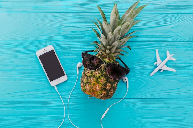 Summer composition with pineapple, sunglasses and mobile phone