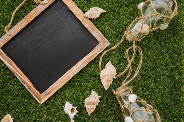 Summer composition with slate, seashells and light bulbs