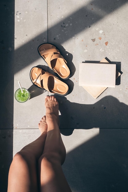 Free photo summer composition with slippers lemonade book and female legs