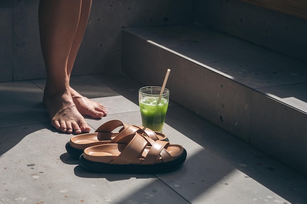 Free photo summer composition with slippers lemonade and female legs