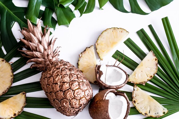 summer composition with tropical leaves and fruits on white