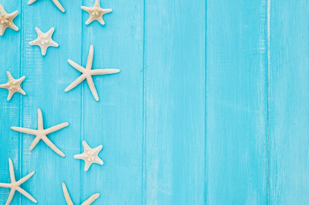 Summer concept with starfish on a blue wooden background with copy space