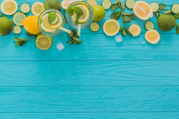 Summer drinks, limes and lemons on wooden surface