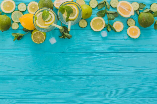 Летние напитки, липы и лимоны на деревянной поверхности