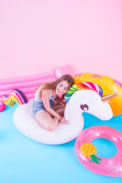 Free photo summer fashion concept with young woman on inflatable unicorn