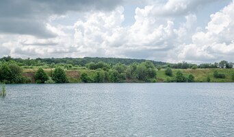 summer landscape in the countryside with river, forest and clouds.