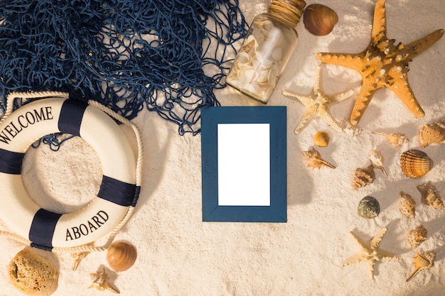 Free photo summer layout of whiteboard starfish seashells lifebuoy and fishing net on sand