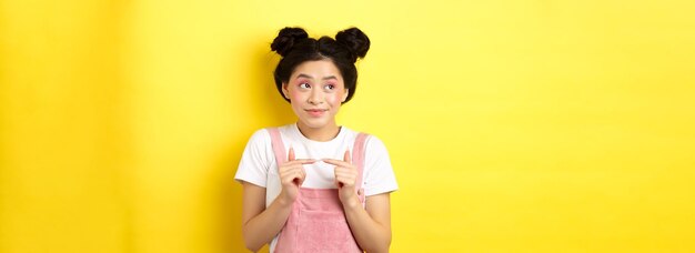 夏のライフ スタイル コンセプトかわいい恥ずかしがり屋のアジアの女の子がよそ見し、アイ コンタクト sta を避ける愚かな笑みを浮かべて