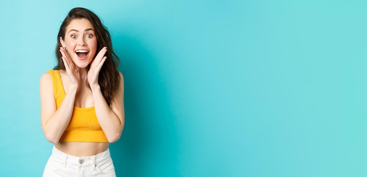 Free Photo summer and lifestyle concept young cheerful woman look with surprised face at camera react to awesom