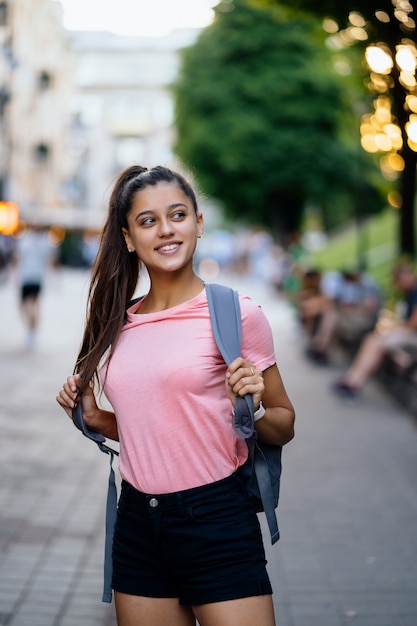 Summer lifestyle fashion portrait of young stylish hipster woman walking on the street