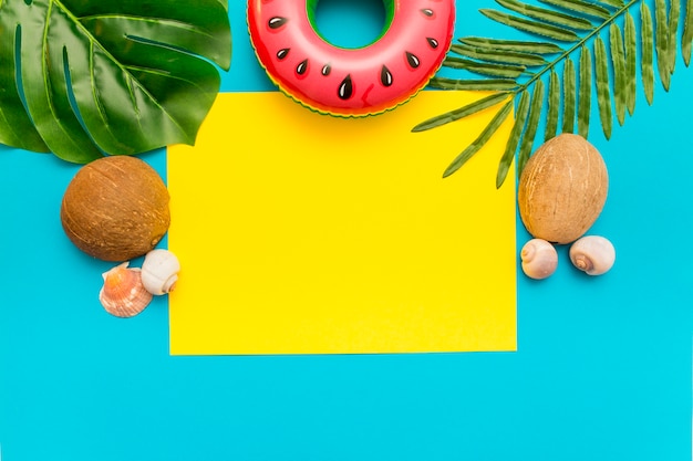 Summer mix with palm leaves and coconut on blue background