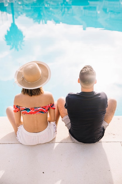 Summer and pool concept with couple from behind