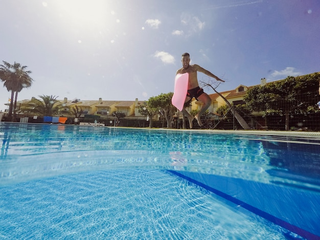 Концепция лета и бассейна с человеком, прыгающим в бассейн