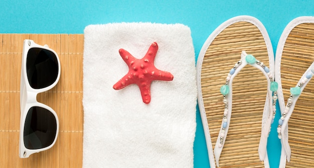 Summer slippers with towel and sunglasses