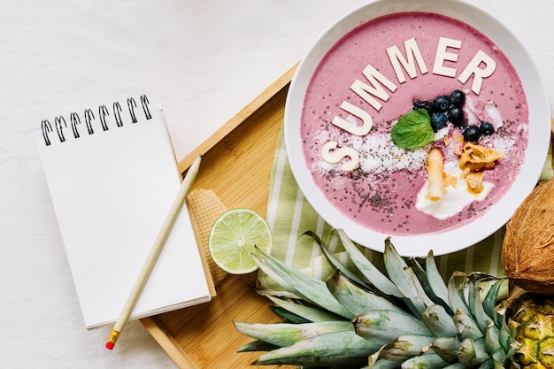Summer smoothie in bowl and notepad