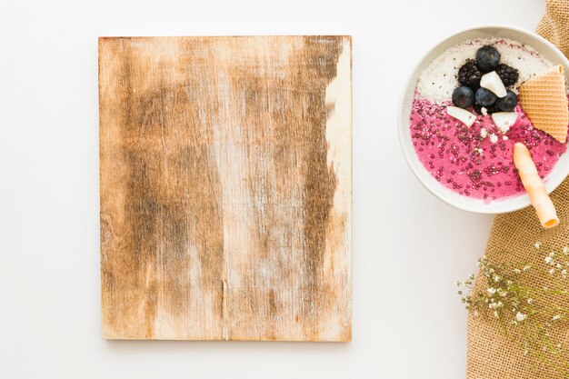 Summer smoothie in bowl and wooden board