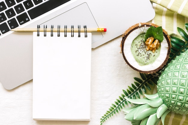 Summer smoothie in coconut with notepad