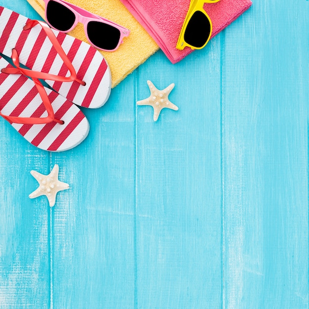 Summer sunbathing beach wooden background, sunglasses, flip flops, copy space