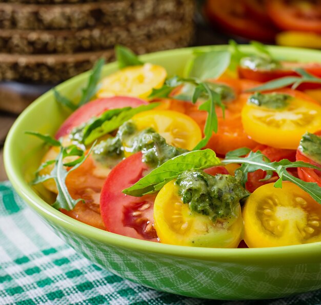 Summer tomato salad with basil, pesto and arugula