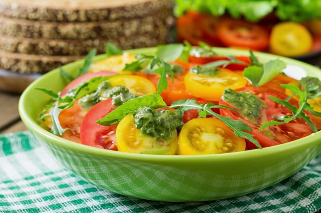 Summer tomato salad with basil, pesto and arugula