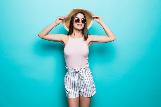 모자와 선글라스에 여름 여행 여자 잔치 여행과 파란색 벽에 고립 된 파티에 대 한 준비. 휴가를 생각하는 매력적인 웃는 소녀. 여름 분위기.