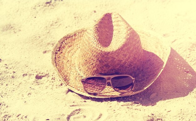 Summer or Vacation Concept. Beautiful Sunglasses with Straw Hat on Sand. Beach. Lifestyle.