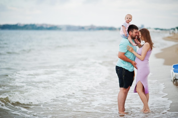 夏休み両親と子供たちとの野外活動幸せな家族の休日海砂浜での父妊娠中の母の赤ん坊の娘