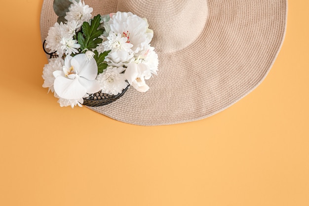 Summer with white fresh flowers and a large wicker hat, on solid.