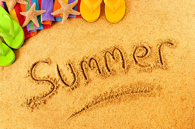 "summer" written in the sand