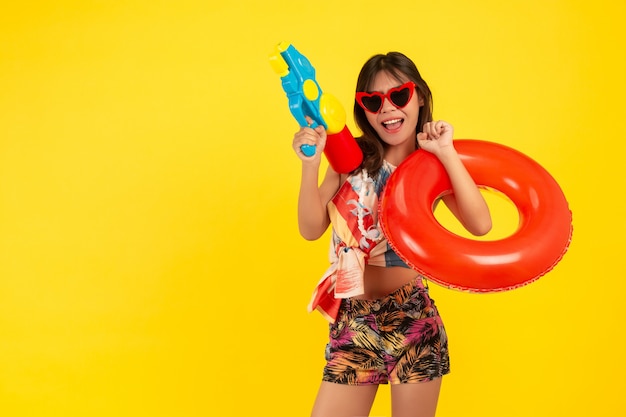 Free photo summer young beautiful woman with water gun and rubber band, songkran holidays