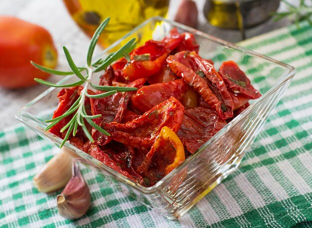 Sun-dried tomatoes with herbs and garlic in wooden bowl