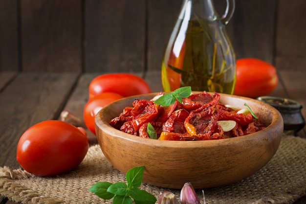 Free photo sun-dried tomatoes with herbs and garlic in wooden bowl