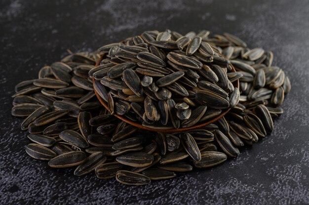 Sun Flower seed in a wooden bowl on the black cement floor.