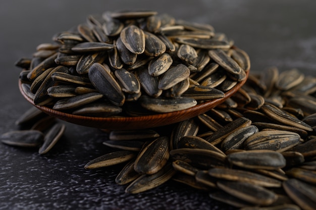 Sun Flower seed in a wooden bowl on the black cement floor.