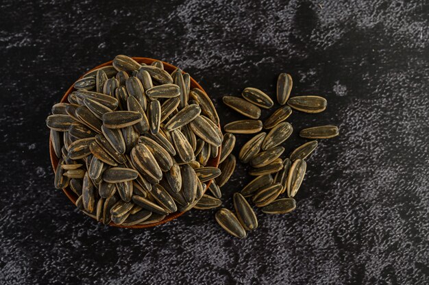 Sun Flower seed in a wooden bowl on the black cement floor.