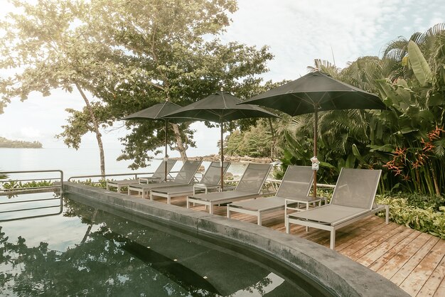 Sun loungers with parasol close to the pool