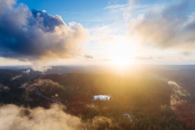 Sun rising over a rock formation covered in greenery